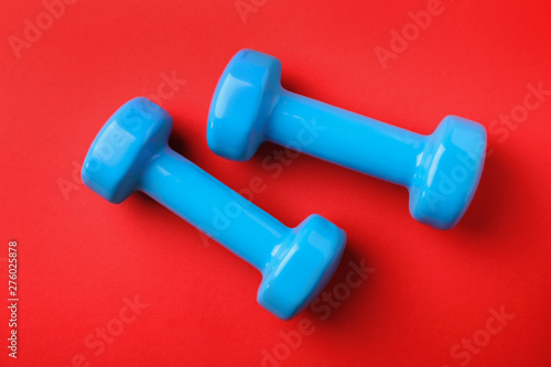 Bright dumbbells on color background, flat lay. Home fitness