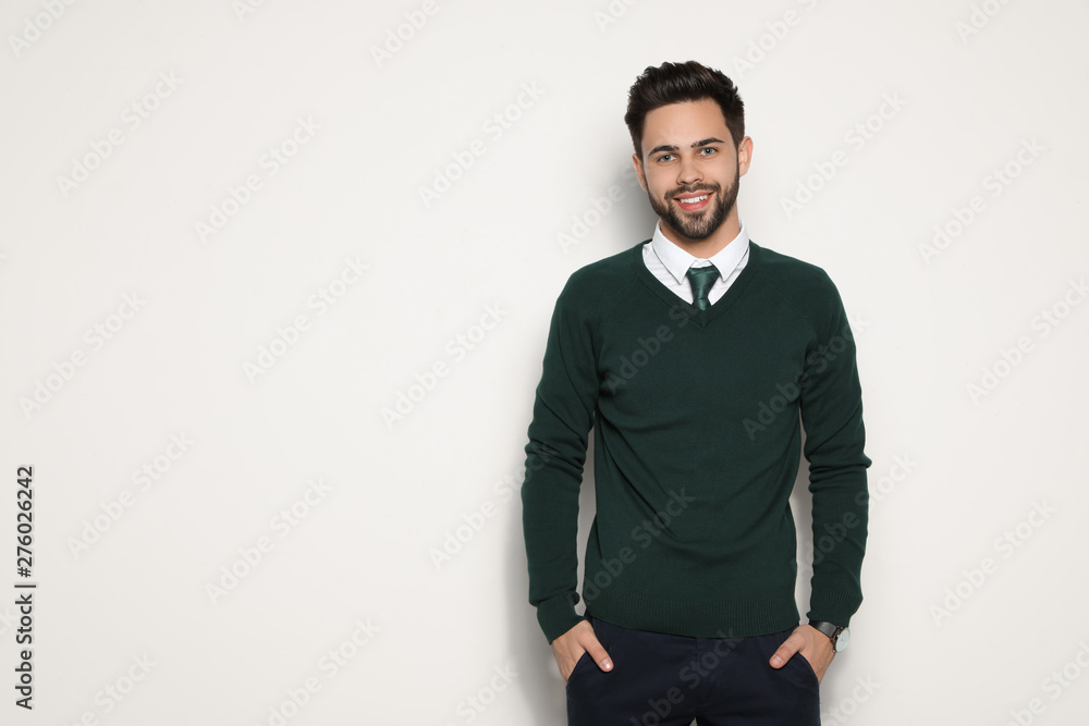 Portrait of handsome young man smiling on light background. Space for text Portrait of handsome young man smiling on light background. Space for text