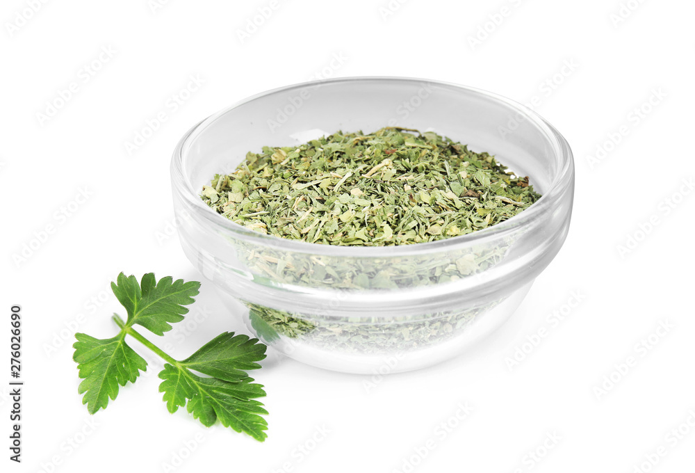 Bowl with dried parsley and fresh twig on white background