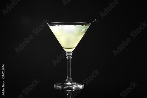 Glass of delicious cucumber martini on dark background
