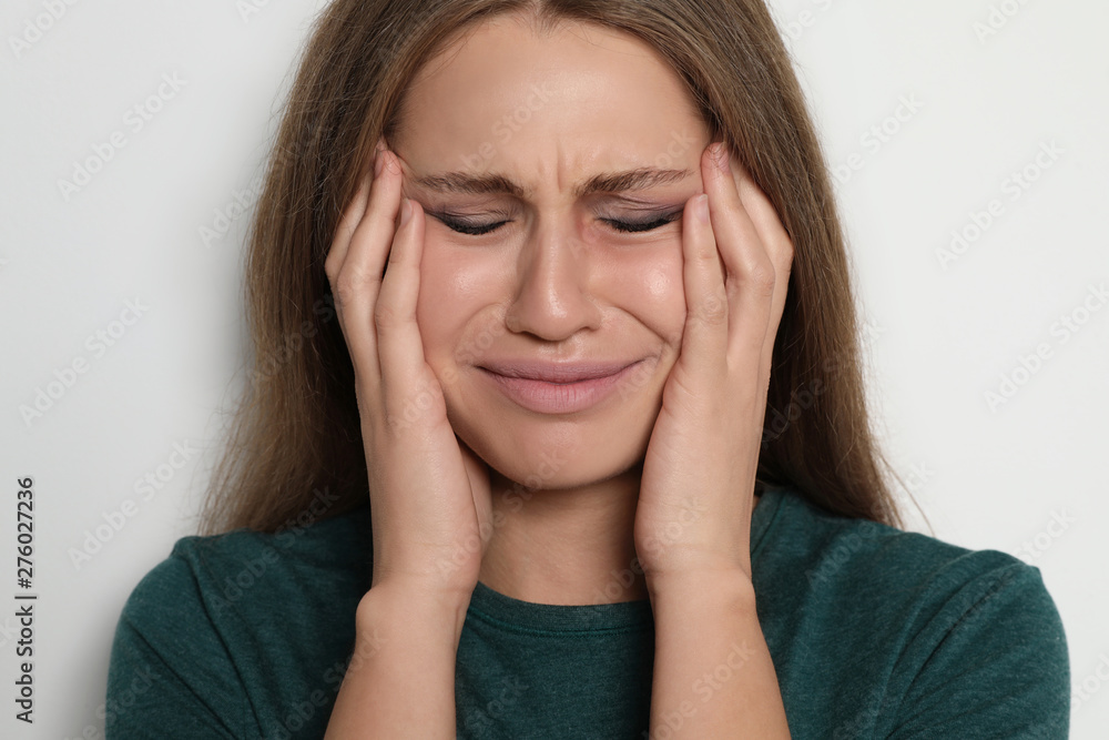 Crying young woman on light background. Stop violence Crying young woman on light background. Stop violence