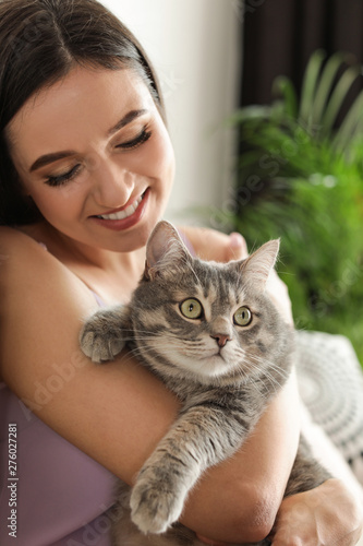 Young woman with cute cat at home. Pet and owner