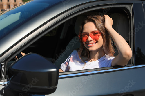 Happy woman with heart shaped glasses in car © New Africa