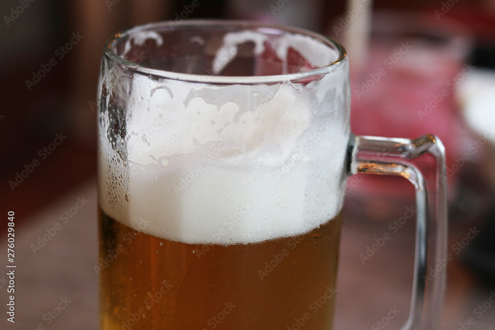 Glass of craft beer with bubble froth on a pub background. Concept drink alcohol for celebration, party, holiday , new year and festival . Glass of craft beer with bubble froth on a pub background. Concept drink alcohol for celebration, party, holiday , new year and festival .