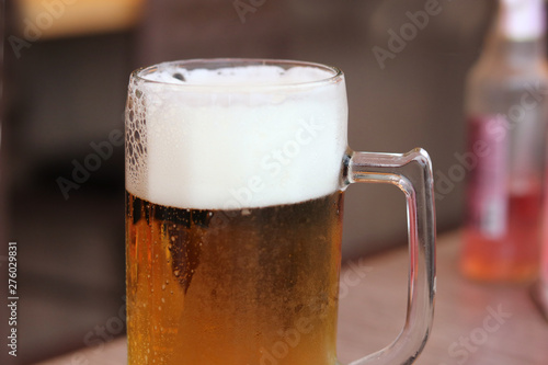 Glass of craft beer with bubble froth on a pub background. Concept drink alcohol for celebration, party, holiday , new year and festival .