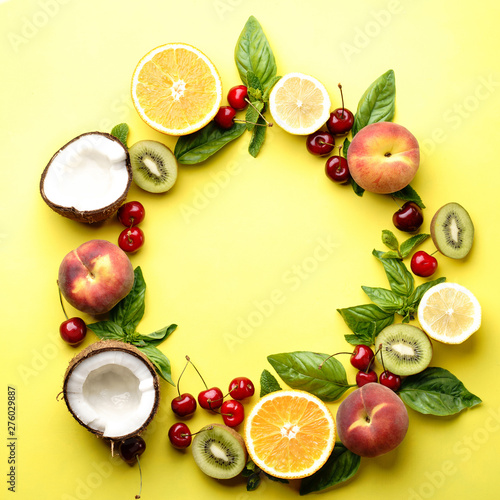 Fototapeta Naklejka Na Ścianę i Meble -  Summer vitamin food concept, various fruit and berries. Peach, kiwi, lemon, cherries, oranges and coconut, creative flat lay on yellow background, top view copy space