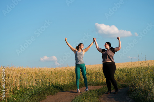 Friendship, personal trainer, group workout, weight loss, sports and health care. Two happy women friends give a five after jogging