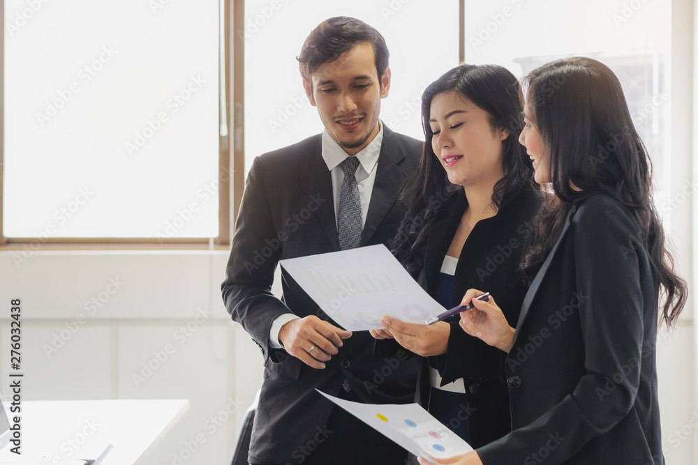 Marketing team consulting sales plan in conference room before meeting.