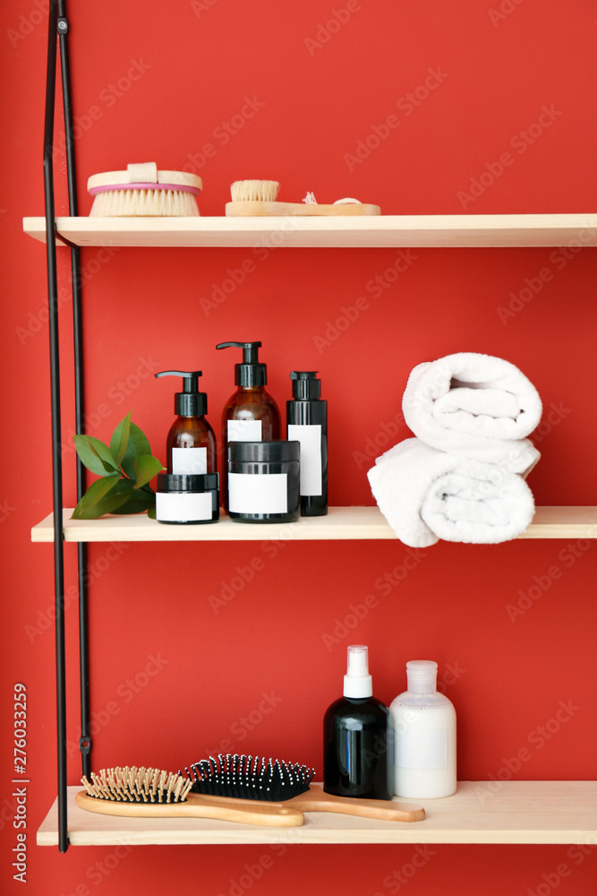 Shampoo, brushes and towels on shelves near color wall Shampoo, brushes and towels on shelves near color wall