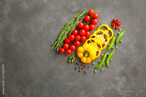 Fresh vegetables with rosemary and spices on grey background