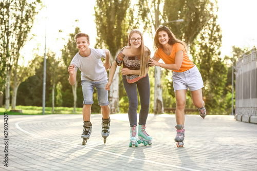 Fototapeta Naklejka Na Ścianę i Meble -  Teenagers on roller skates outdoors