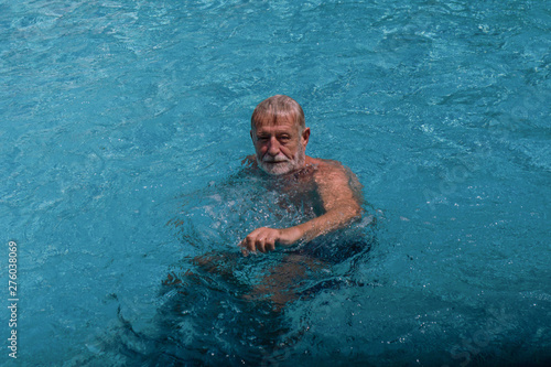 senior male swimming in swimming pool