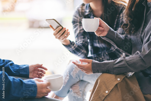 People using phone, talking and drinking coffee together