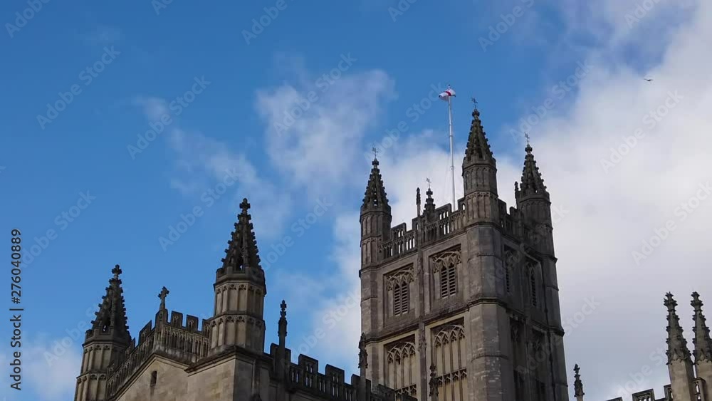 Super Slow Motion Shot of Seagull Flying in and out of Frame with Tower of Bath Abbey in Somerset, England in the Background on Sunny Summer’s Day with Saint George’s Cross Flapping in the Wind Super Slow Motion Shot of Seagull Flying in and out of Frame with Tower of Bath Abbey in Somerset, England in the Background on Sunny Summer’s Day with Saint George’s Cross Flapping in the Wind