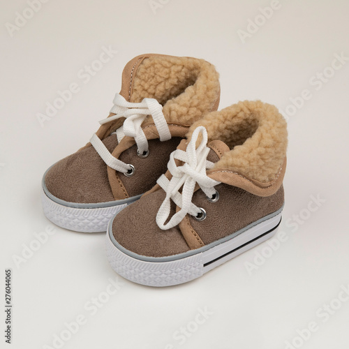 Brown winter baby shoes on white background
