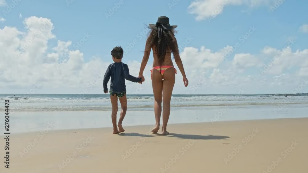 Mother playing with her son with water on the beach. Mother playing with her son with water on the beach.