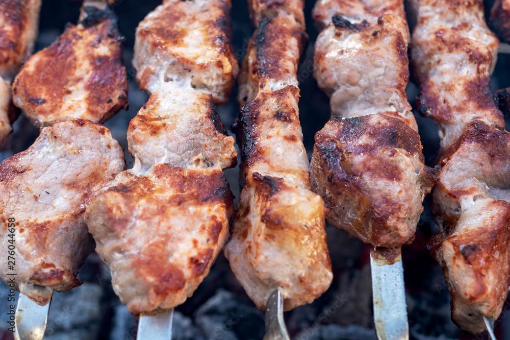 Shashlik or Shish kebab popular in Eastern Europe. BBQ fresh meat pork slices. Grill on charcoal and flame, picnic