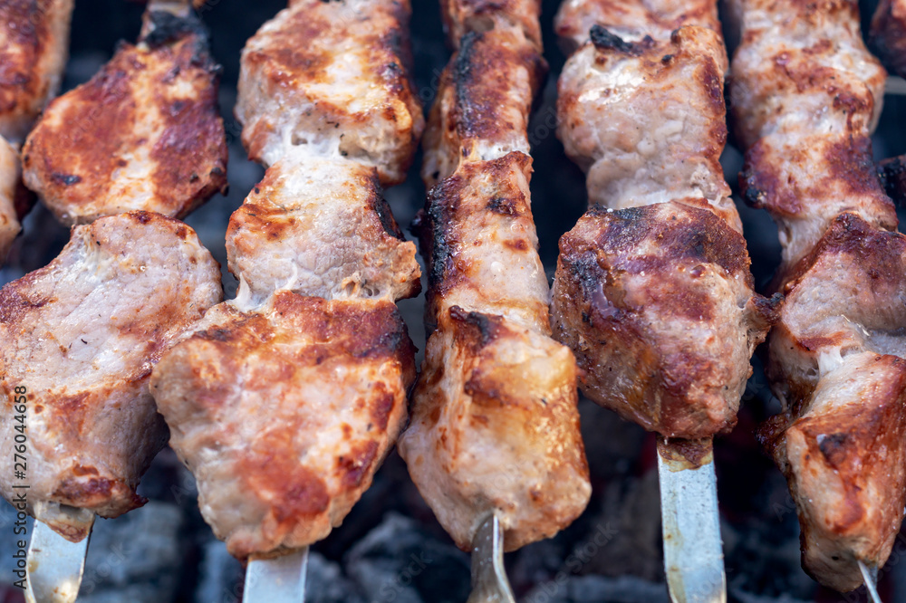 Shashlik or Shish kebab popular in Eastern Europe. BBQ fresh meat pork slices. Grill on charcoal and flame, picnic Shashlik or Shish kebab popular in Eastern Europe. BBQ fresh meat pork slices. Grill on charcoal and flame, picnic