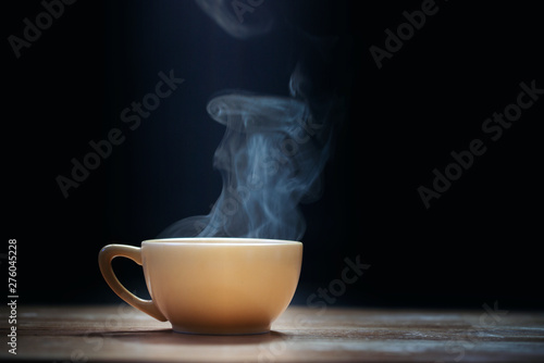 Cup of coffee with steam on black background