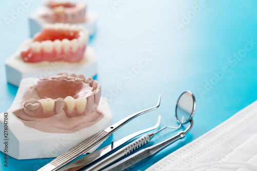 Artificial removable partial denture or temporary partial denture on blue ground.