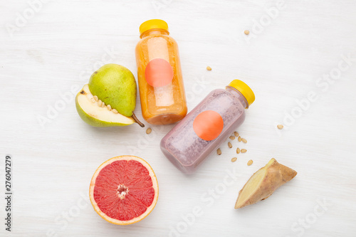 Fruit juice in a jar next to slices of pear and pine nuts standing on a white table. Concept of healthy snack and lunch at work.