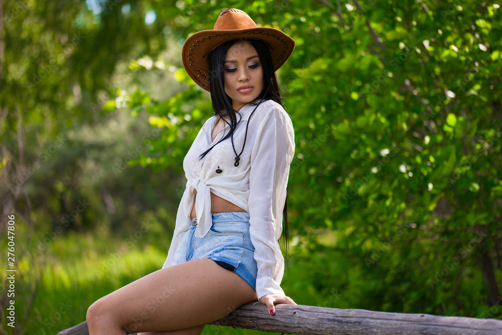 Young asian woman in hat on a nature cowboy