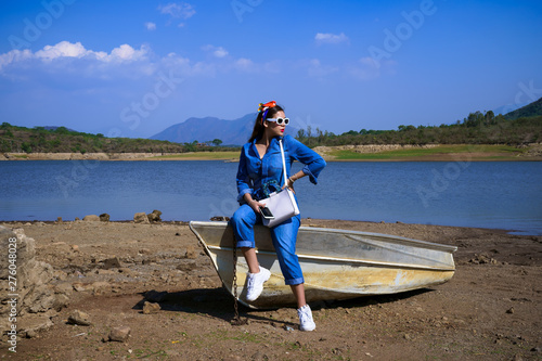La joven está sentada sobre la lancha que está en la presa Corrinchis en Mascota Jalisco. photo
