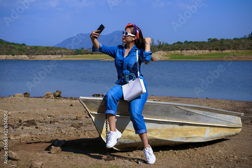 La joven se está tomando un selfie en la presa Corrinchis en Mascota Jalisco. photo