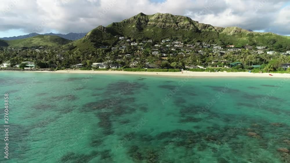 Aerial view of Lanikai beach, Honolulu, Hawaii, low angle view with drone camera moving backwards, clear green water with reef Aerial view of Lanikai beach, Honolulu, Hawaii, low angle view with drone camera moving backwards, clear green water with reef