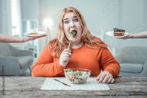 Emotional blonde woman keeping eyes wide opened photo