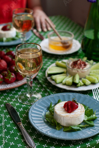 A gourmet dinner for two  grilled camembert  white wine and various appetizers.