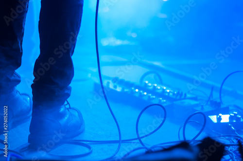 Piernas de músico de rock con pedales de efectos con humo durante concierto