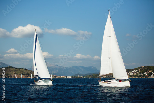 Sailing ship yachts with white sails in the open sea..