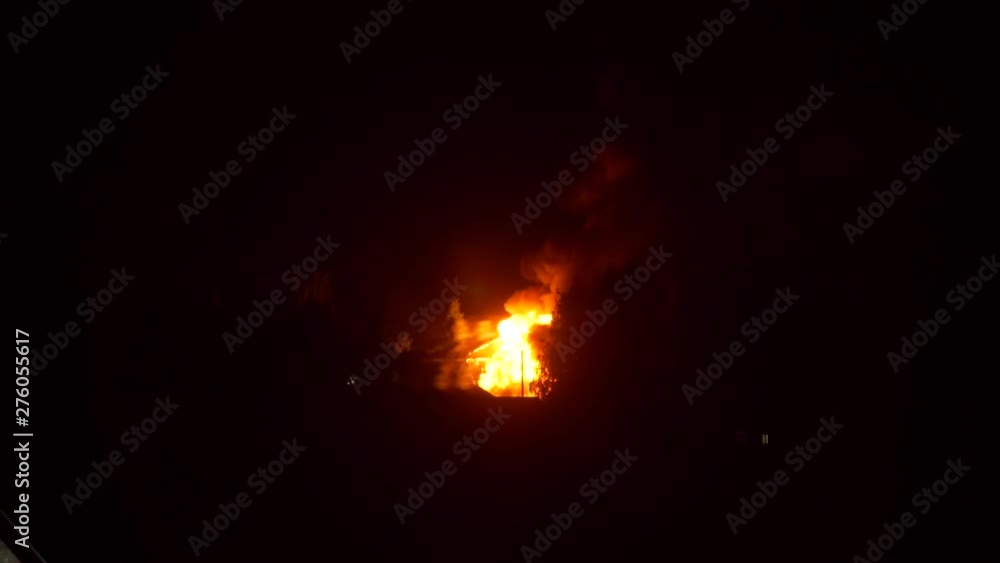 Building on Fire in Night Time. A Blazing Fire Burns Through the Roof Rafters of an Farm House. Arson or Natural Disaster Concept Building on Fire in Night Time. A Blazing Fire Burns Through the Roof Rafters of an Farm House. Arson or Natural Disaster Concept