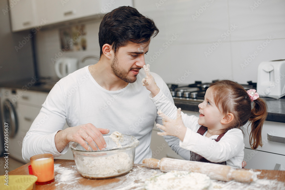 Family in a kitchen. Handsome father with litle daughter Family in a kitchen. Handsome father with litle daughter