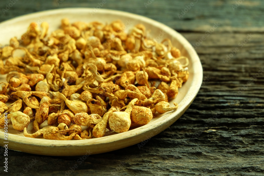 Dried cordyceps militaris in wooden dish on old wooden floors Dried cordyceps militaris in wooden dish on old wooden floors
