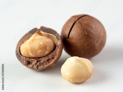 Three peeled macadamia nuts on white background. Set of three macadamia nuts - whole unshelled, with open shells, and shelled. isolated on white. Copy space for text.