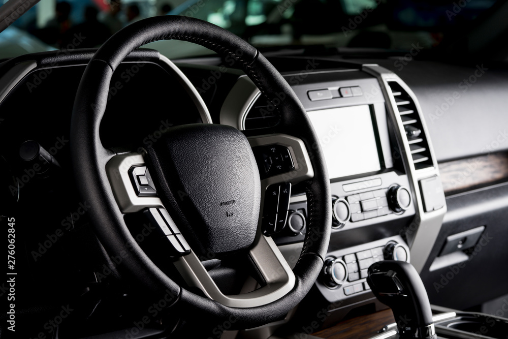 Modern pickup truck interior, touch screen panel, leather seats and automatic transmission lever - dark light