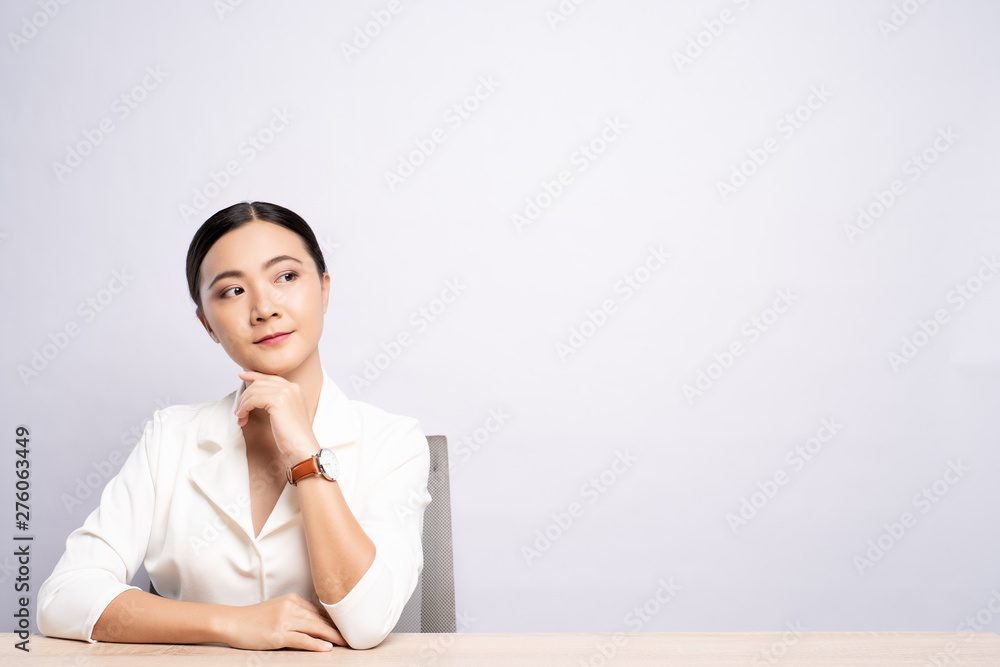 Portrait of a confident woman sitting isolated over background Portrait of a confident woman sitting isolated over background