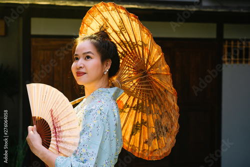 Lifestyle series  Asian woman holding paper umbrella and paper fan in ryokan