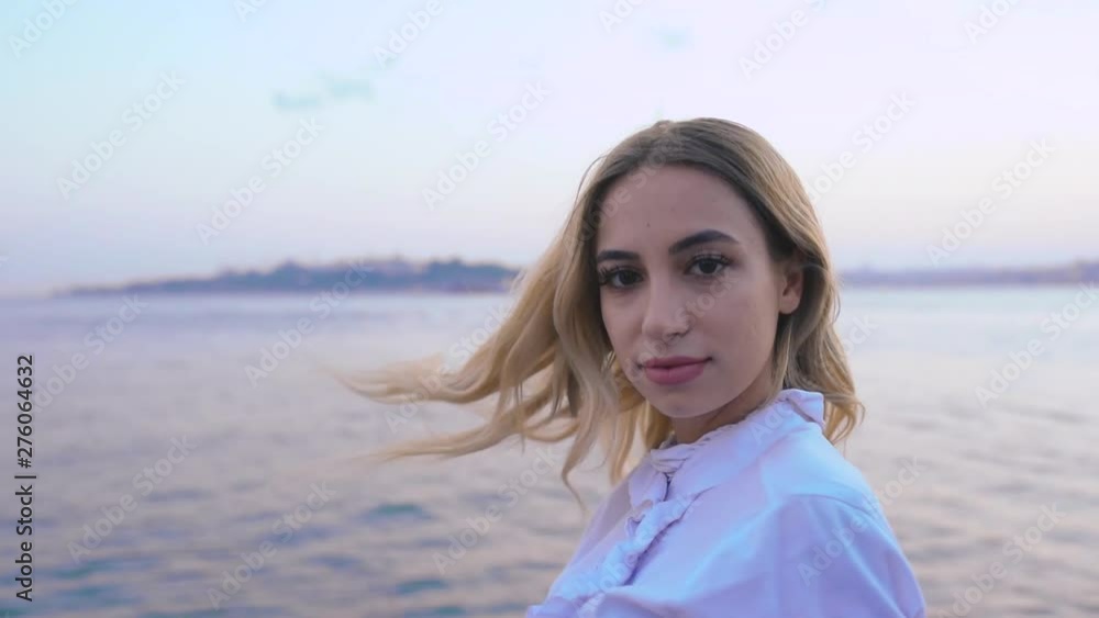 Slow Motion:Beautiful girl enjoys sunset view of bosphorus with view of Maiden Tower at background in Istanbul Slow Motion:Beautiful girl enjoys sunset view of bosphorus with view of Maiden Tower at background in Istanbul