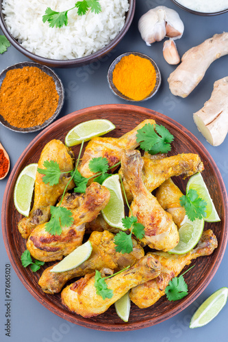 Indian chicken tandoori, marinated in greek yogurt  and spices, served with lime wedges and cilantro, vertical, top view