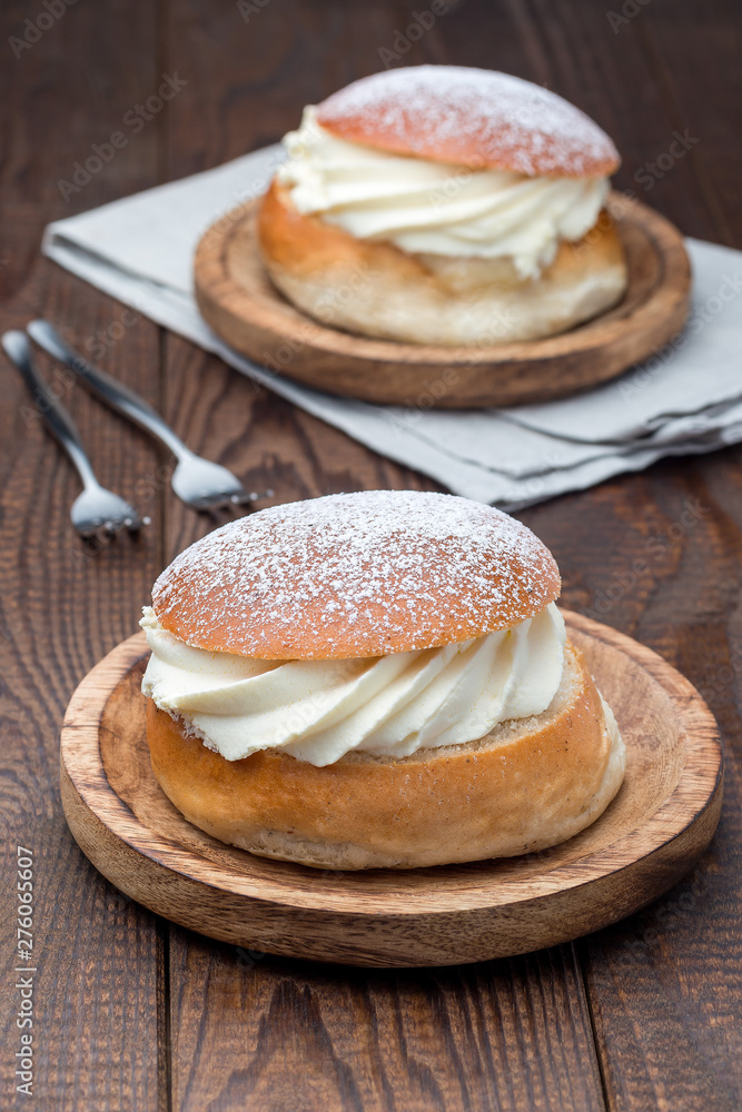 Traditional swedish dessert Semla, also called Shrove bun, with almond paste and whipped cream filling, vertical Traditional swedish dessert Semla, also called Shrove bun, with almond paste and whipped cream filling, vertical