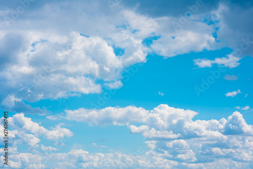 Beautiful white cumulonimbus clouds against the background of the bright blue sky © chernikovatv