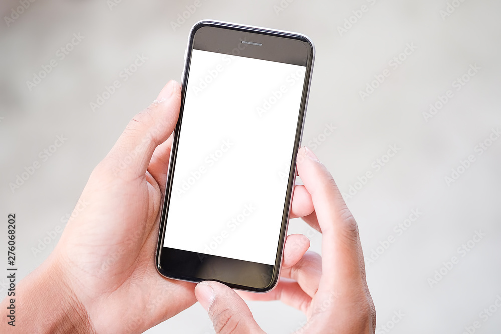  Cropped shot view of man hands holding smart phone with blank copy space screen for your text message or information content, female reading text message on cell telephone during in urban setting. 