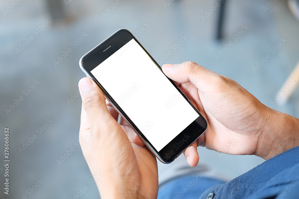  Cropped shot view of man hands holding smart phone with blank copy space screen for your text message or information content, female reading text message on cell telephone during in urban setting. 