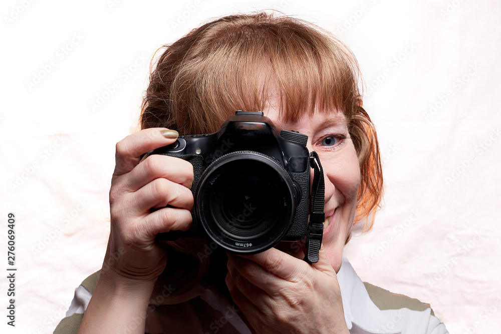 Blonde-haired female photographer with photo camera in her hands on a white background Blonde-haired female photographer with photo camera in her hands on a white background