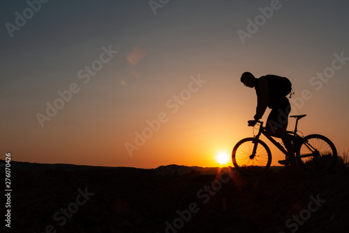 Man with mountain bike at sunrise