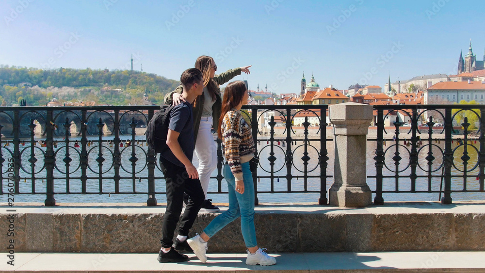 Three friend walking on the bridge and looking around in the Czech, Prague