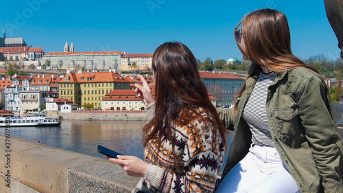 Two young women standing on bridge and looking right. Czech, Prague photo